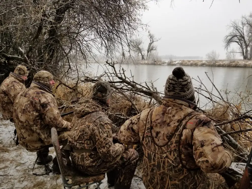 four duck hunters sitting in a duck blind