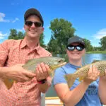 man and woman holding fish they caught