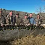 Group poses with their harvest of ducks from a successful duck hunt