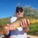 man wearing a black hat holding a fish